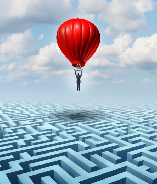 Rise above adversity solution Leadership with a businessman flying and soaring over a complicated maze with the help of a hot air balloon as a business concept of innovative creative thinking for financial success.